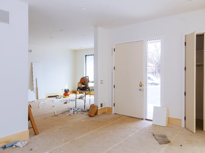 Interior of a room under renovation with construction tools and materials scattered on the floor. reconstruction services
