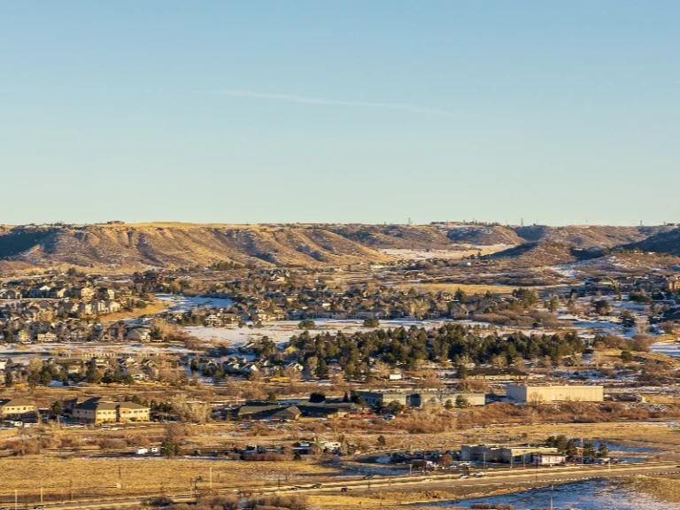 Suburban area with scattered houses and buildings at the base of rolling hills under a clear sky. water damage restoration in Parker CO